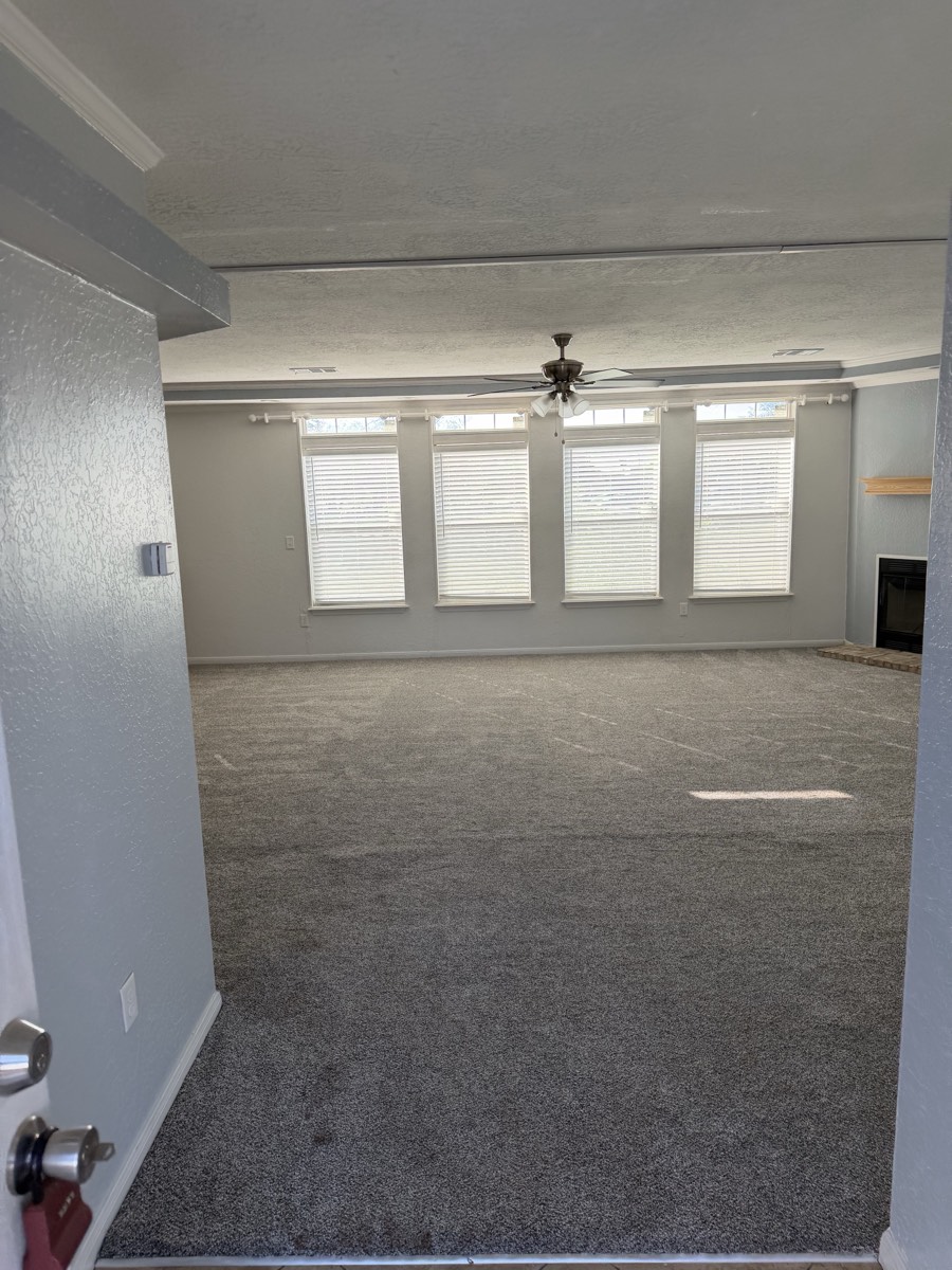 2023 Deming Solitaire 32×82 — Living room with fireplace and tall windows