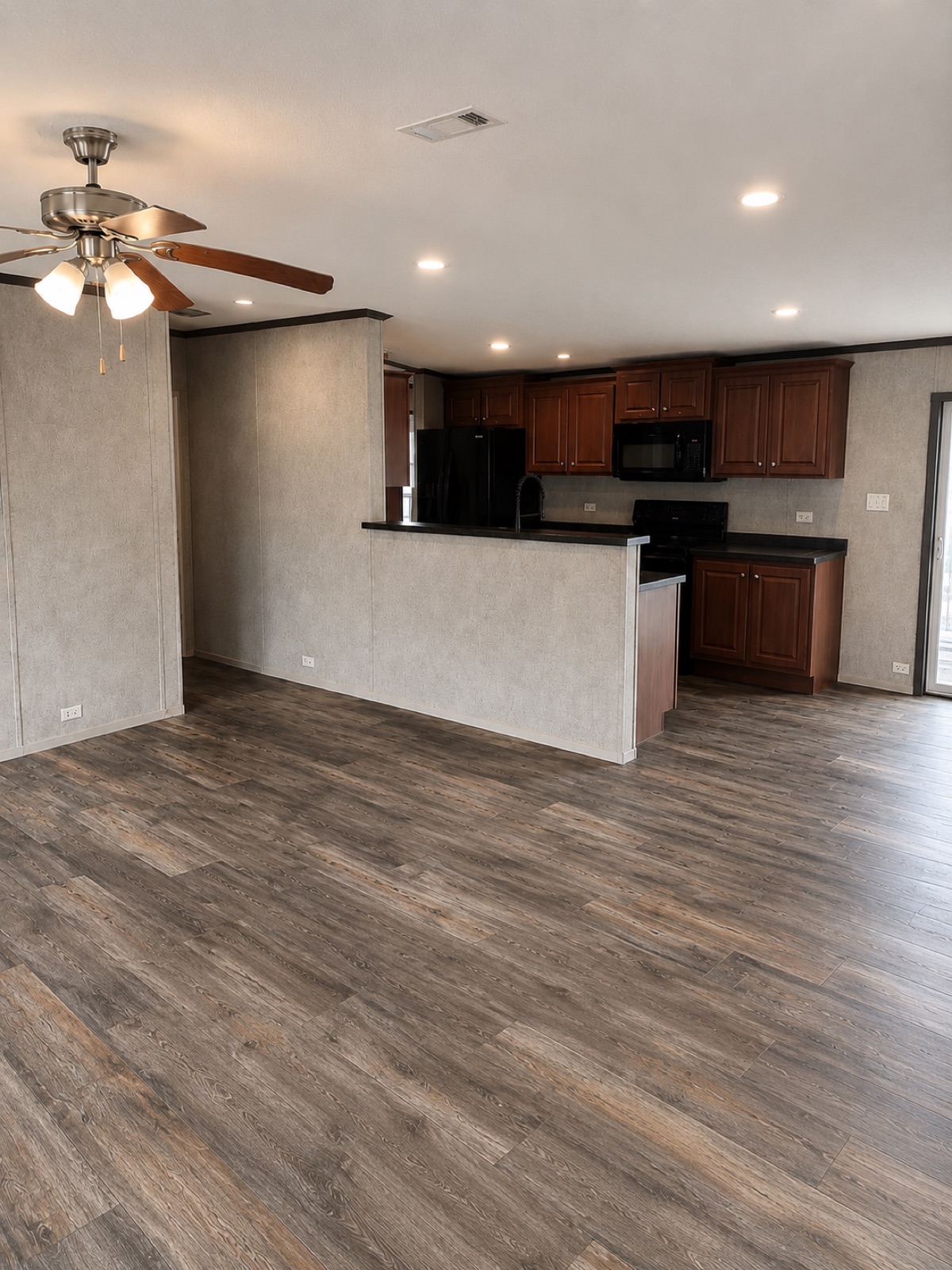 Living area with ceiling fan and kitchen